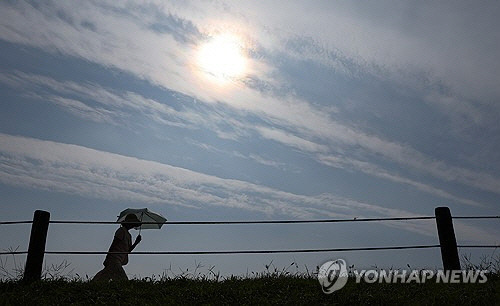 늦더위가 이어진 10일 오전 서울 송파구 올림픽공원에서 양산을 쓴 시민이 산책하고 있다. [연합뉴스]