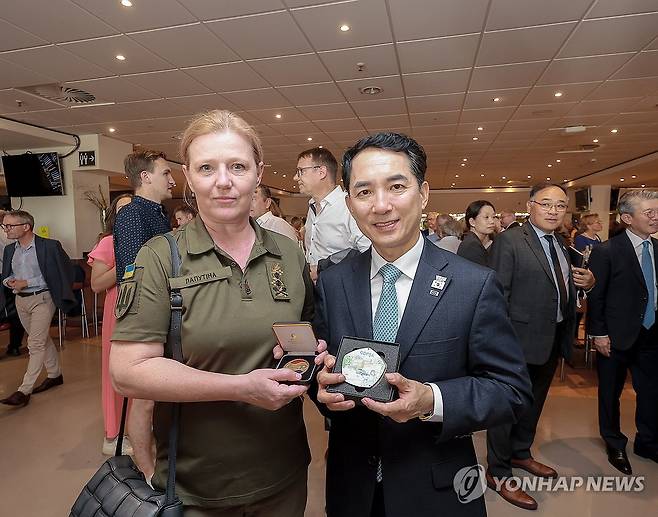 박민식 장관, 우크라이나 보훈부 장관과 기념 촬영 (서울=연합뉴스) 박민식 국가보훈부 장관이 9일(현지시간) 독일 뒤셀도르프에서 열리고 있는 '2023 독일 인빅터스 게임' 개회식에서 율리아 라푸티나 우크라이나 보훈부 장관과 기념품을 교환 후 기념 촬영하고 있다. 2023.9.10 [국가보훈부 제공. 재판매 및 DB 금지] photo@yna.co.kr