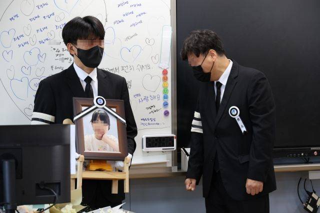 악성민원으로 세상을 뜬 대전 초등 교사의 유족들이 9일 오전, 교사가 재직하던 유성구 한 초등학교 5학년 교실에 영정사진을 들고 들어서며 눈물을 흘리고 있다. [사진출처=연합뉴스]