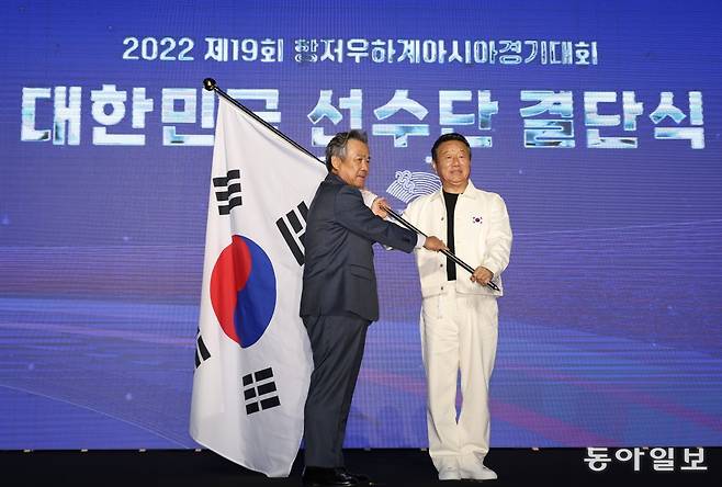 12일 서울 송파구 올림픽공원 올림픽홀에서 2022 항저우 아시안게임 대한민국 선수단 결단식이 열렸다. 이기홍 대한체육회장이 최영 선수단장에게 태극기를 건네고 있다. 김재명 기자 base@donga.com