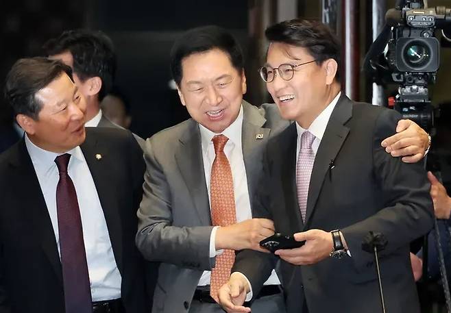 People Power Party (PPP) leader Kim Gi-hyeon greets lawmaker Yoon Sang-hyun (right) at a general meeting of PPP lawmakers at the National Assembly on May 17. Left is Lee Chul-gyu, the party’s secretary general. Yonhap News