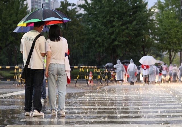 지난 5일 오후 서울 잠실야구장 인근에서 시민들이 우산을 쓰고 걸어가고 있다. 연합뉴스.