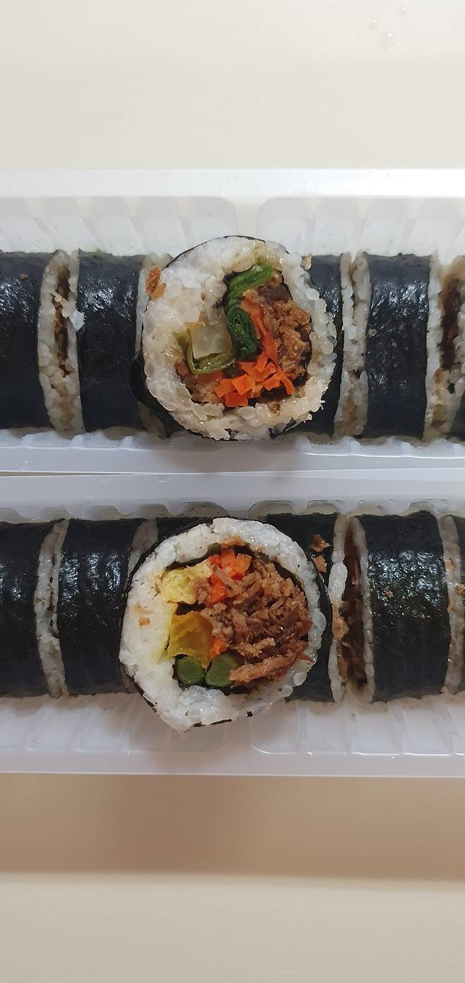 ‘11시45분’의 우엉유부김밥(위)과 숯불향불고기김밥. 우엉유부김밥은 밥에 알곤약을 섞어 칼로리를 낮췄으며 흰색 무첨가 난무지를 썼다. 숯불향불고기김밥은 국내산 돼지고기를 사용했으며 시금치 대신 마늘종을 넣었다. 김희원 기자