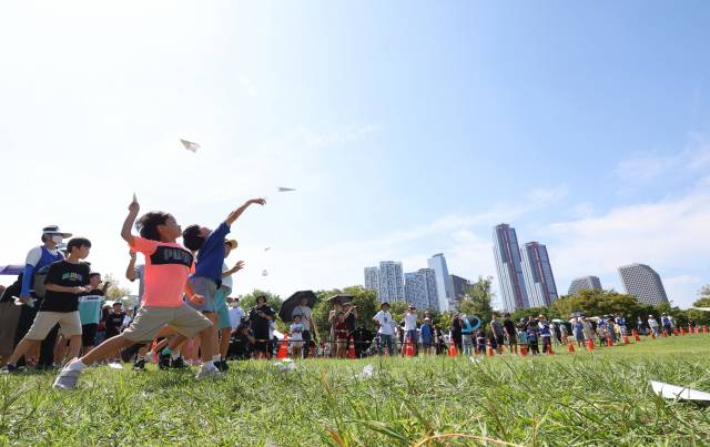 9일 서울 영등포구 여의도 한강공원 잔디마당에서 열린 2023 한강 종이비행기 축제에 참가한 어린이들이 힘차게 종이비행기를 날리고 있다. /연합뉴스