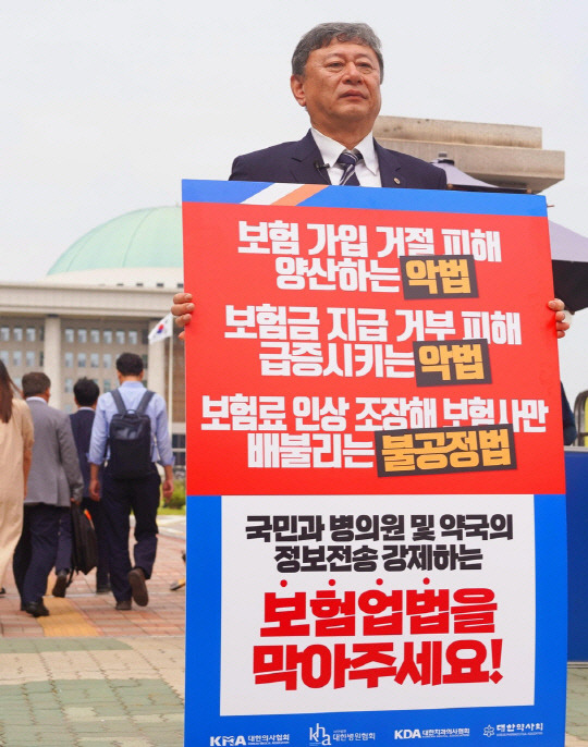 이정근 대한의사협회(의협) 상근부회장이 12일 국회 앞에서 실손보험 청구 간소화 내용을 담은 보험업법 개정안에 반대하는 1인시위를 펼치고 있다. [대한의사협회 제공]