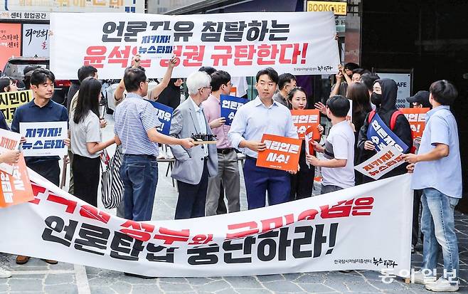 14일 검찰 수사관들이 건물 진입을 시도하자 뉴스타파 직원들이 구호를 외치는 도중 고개를 돌려 수사관들을 바라보고 있다.  박형기 기자 oneshot@donga.com