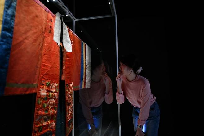 방탄소년단(BTS)의 RM(본명 김남준)의 후원으로 보존처리를 마친 미국 로스앤젤레스 카운티미술관(LACMA) 소장의 활옷을 전시 관계자가 살펴보고 있다. 이 활옷은 다시 미국으로 돌려보내기 전에 국내에서 처음 선보이는 것이다. 국립고궁박물관 제공