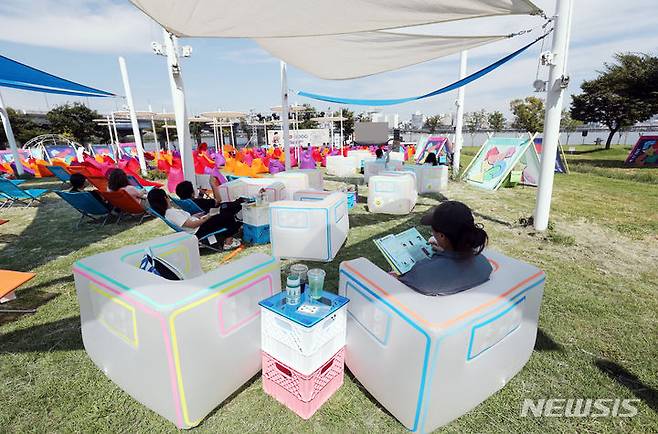 [서울=뉴시스] 김진아 기자 = 지난 2일 오후 서울 여의도 한강공원에서 열린 '책읽는 한강공원'을 찾은 시민들이 책을 읽고 있다. 서울시는 뚝섬·여의도 한강공원의 '책읽는 한강공원'을 새 단장하고 2일부터  10월28일까지 매주 토요일 낮 12시부터 저녁 8시까지 운영한다. 여의도는 '철수네 슈퍼', 뚝섬은 '영희네 문방구'라는 간판을 내건 야외 도서관에서 책을 빌려서 읽을 수 있다. 2023.09.02. bluesoda@newsis.com