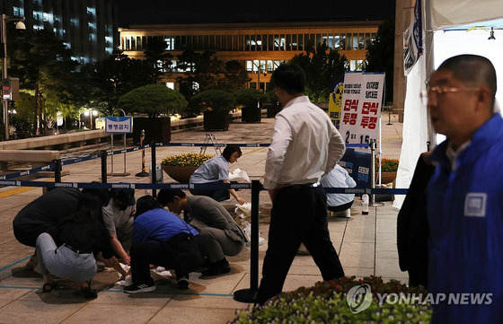 지난 14일 국회 본청 앞에 설치된 더불어민주당 단식 농성장에서 한 시민이 휘두른 흉기에 경찰이 다치는 사건이 발생했다. 국회와 당 관계자들이 사건 현장을 정리하고 있다. 〈사진=연합뉴스〉