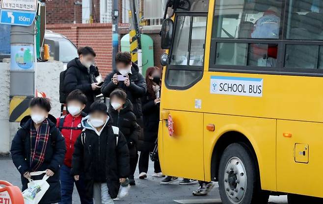 일부 시설을 제외한 실내에서 마스크 착용 의무가 해제된 30일 오전 서울 광진구 광장초등학교 앞에 정차한 스쿨버스에서 마스크를 착용한 학생들이 내리고 있다.ⓒ뉴시스