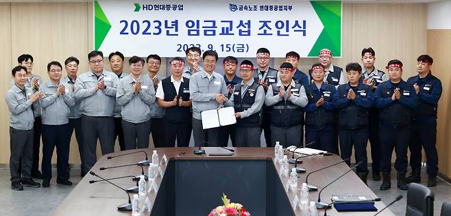 이상균(앞줄 왼쪽 여섯번째) HD현대중공업 사장이 15일 울산 본사에서 열린 ‘2023년 임금교섭 조인식’에서 정병천(앞줄 왼쪽 일곱번째) 전국금속노동조합 현대중공업지부 지부장과 악수하며 기념촬영을 하고 있다. [HD현대중공업 제공]