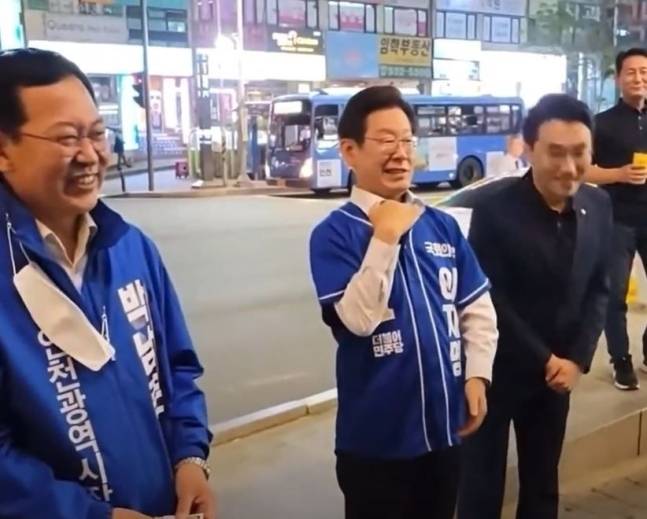 지난해 5월23일 국회의원 보궐선거 인천 계양을 지역 유세 중인 당시 이재명 더불어민주당 총괄 선거대책위원장(가운데)이 한 시민에게 “투표하면 이긴다”며 “이번에 이재명 지면 정치생명 끝장난다”고 말하면서 ‘끽’하고 목 긋는 시늉을 하고 있다. 온라인 커뮤니티 캡처