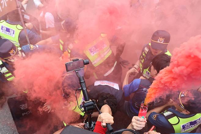 전국철도노동조합(철도노조) 파업 사흘째인 16일 오후 서울 용산구 남영역 인근에서 열린 ‘철도노조 총파업 승리 결의대회’에서 상징의식에 사용된 연막탄을 빼앗으려는 경찰과 이를 막으려는 조합원들이 충돌을 빚고 있다. 연합뉴스