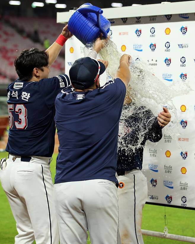 ▲ 양석환과 호세 로하스가 강승호에게 물을 붓고 있다. ⓒ 두산 베어스