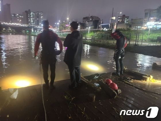 소방이 20일 오후 갑작스러운 많은 비로 불어난 물에 휩쓸려간 여성을 찾기 위해 수색작업을 벌이고 있다. / 사진 = 부산소방재난본부