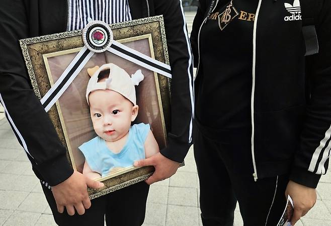 [수원=뉴시스] 변근아 기자=경기 화성시의 한 어린이집 원장의 아동학대 행위로 숨진 천모군의 부모가 아이의 영정사진을 들고 있다. 2023.04.20. gaga99@newsis.com *재판매 및 DB 금지