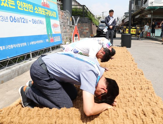 지난 6월 14일 인천 남동구 소래포구 전통어시장에서 상인들이 자정대회를 열고 신뢰 회복을 약속하며 사과하고 있다. 연합뉴스