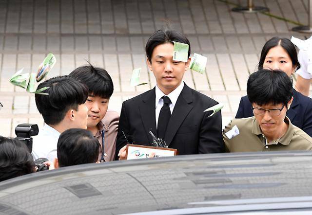 마약 상습 투약 혐의를 받는 배우 유아인(본명 엄홍식)이 21일 서울 서초구 서울중앙지방법원에서 열린 구속 전 피의자심문(영장실질심사)을 마치고 돌어가던 중 현장에 있던 유튜버가 "영치금으로 사용하라"고 던진 돈다발을 맞고 있다. 김예원 인턴기자