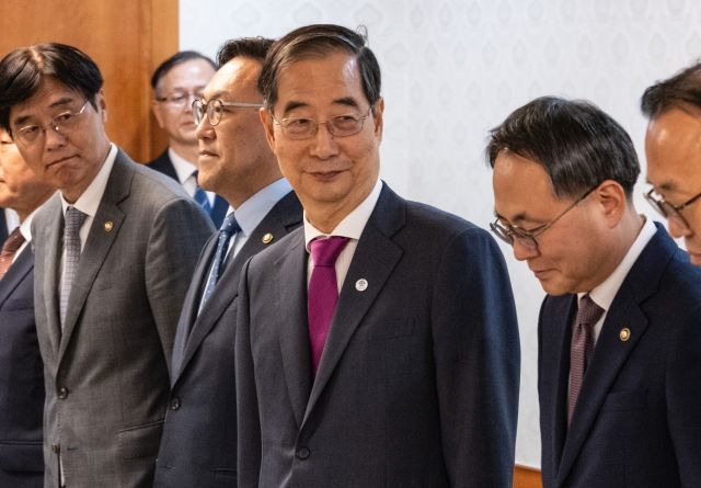 한덕수 국무총리가 21일 정부서울청사에서 열린 차관급 임명장 수여식에서 임명 대상자들과 기념 촬영을 마친 뒤 미소짓고 있다. 수여식은 한 총리에 대한 해임건의안이 국회를 통과했다는 소식이 전해진 이후 열렸다. 연합뉴스