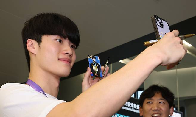 2022 항저우 아시안게임에 출전하는 대한민국 수영대표팀의 황선우가 21일 중국 항저우 샤오산 국제공항으로 입국해 팬의 요청에 인증사진을 촬영하고 있다.  2023.9.21 연합뉴스