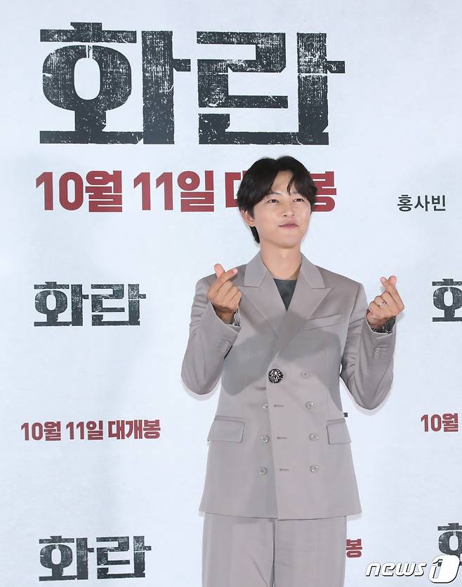 배우 송중기가 22일 서울 강남구 메가박스 코엑스에서 열린 영화 '화란‘(감독 김창훈) 언론시사회에서 손가락 하트를 그리고 있다.ⓒ News1 권현진 기자