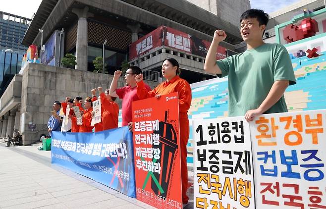 환경운동연합 등 환경단체 회원들이 21일 오전 서울 종로구 세종문화회관 앞에서 일회용 컵 보증금제 전국 시행 철회를 규탄하는 퍼포먼스를 하고 있다./연합뉴스.
