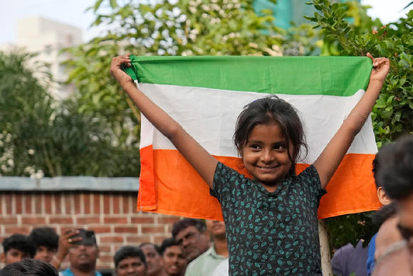 인도 뭄바이에서 지난 8월 24일 국기를 든 소녀가 무인 우주선 '찬드라얀 3호'의 달 착륙선 '바크람'이 달 남극 부근에 착륙하는 것을 지켜보고 있다.  [사진=뭄바이=AP/뉴시스]