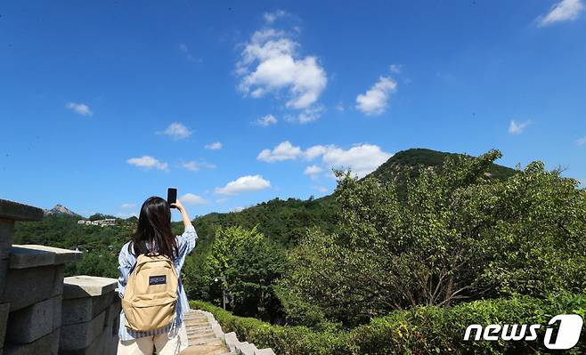 맑고 청명한 가을날씨를 보인 22일 오후 서울 종로구 한양도성 순성길을 찾은 한 시민이 맑고 푸른 가을하늘을 사진에 담고 있다. 기상청은 주말까지 일교차가 크고 맑은 전형적인 가을 날씨를 보이겠다고 밝혔다. /사진=뉴스1