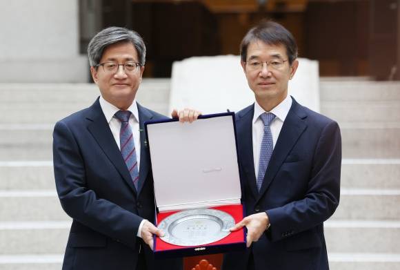 기념패 받는 김명수 대법원장 - 김명수(왼쪽) 대법원장이 22일 오전 서울 서초구 대법원에서 열린 퇴임식에서 선임 대법관인 안철상 대법관으로부터 기념패를 받고 있다. 2017년 9월 25일 취임한 김 대법원장은 6년의 임기를 마치고 퇴임한다. 2023.9.22