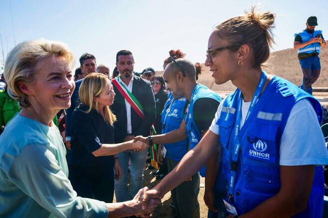 우르줄라 폰데어라이엔 EU 집행위원장(왼쪽 첫 번째)과 조르자 멜로니 이탈리아 총리(왼쪽 두 번째)가 17일(현지 시각) 이탈리아 최남단 람페두사섬을 방문해 유엔난민기구(UNHCR) 직원들과 악수하고 있다. /AFP 연합뉴스