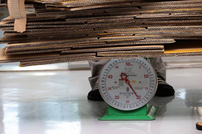 킬로그램(㎏)당 50~100원 하는 폐상자가 저울에 올려져 있다.