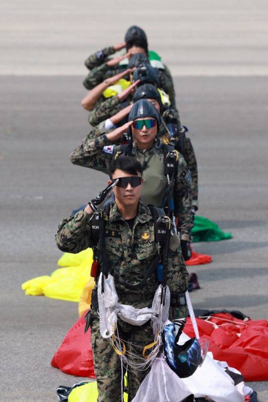 오는 26일 건군 75주년 국군의 날 행사에서 집단강하를 선보일 장병들이 본행사를 앞두고 진행한 공중훈련을 마치고 경례하고 있다. 국방일보 제공