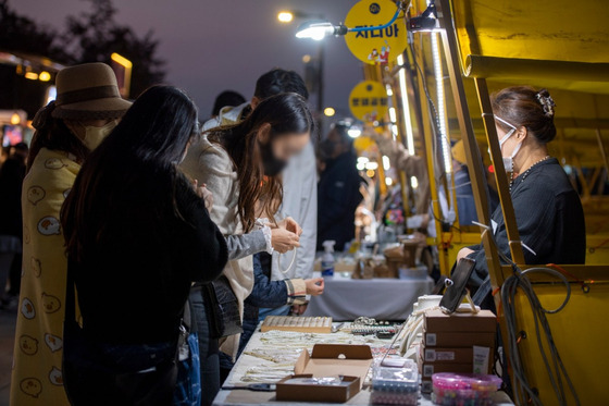 Visitors check the handicraft booths at Hangang Moonlight Market at Yeouido Hangang Park, Yeongdeungpo District, western Seoul. [SEOUL METROPOLITAN GOVERNMENT]