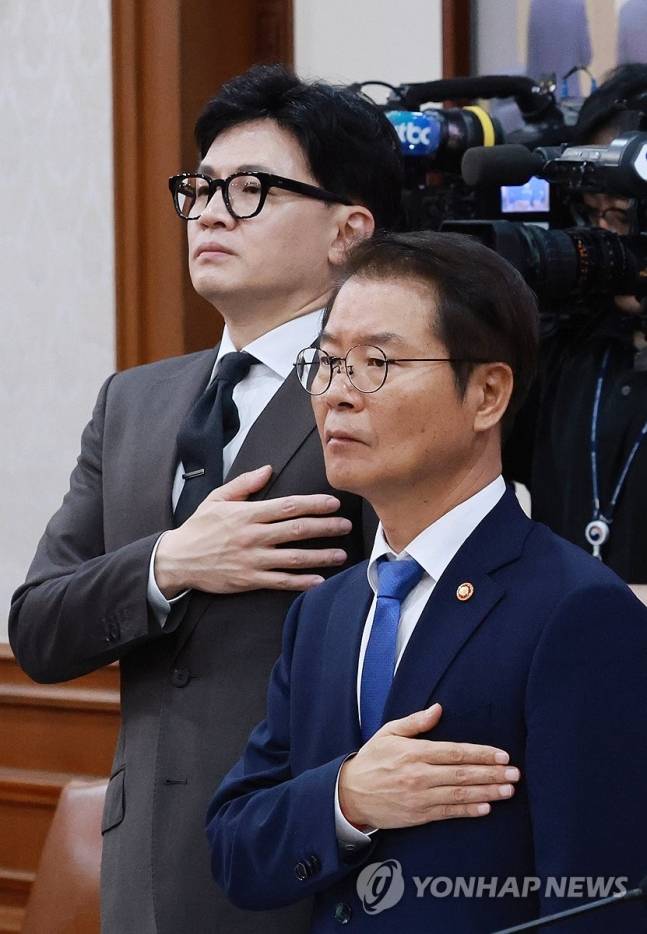 이정식 고용노동부 장관(오른쪽)과 한동훈 법무부 장관(왼쪽)이 19일 오전 서울 종로구 정부서울청사에서 열린 국무회의에 참석해 국기에 대한 경례를 하고 있다. [연합]