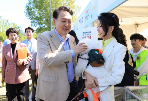 윤석열 대통령과 김건희 여사가 24일 서울 용산어린이정원에서 추석을 앞두고 열린 ‘추석맞이 팔도장터’를 찾아 강아지를 살펴보고 있다(사진=대통령실 제공).