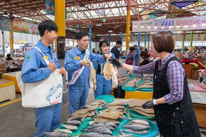 이철호 광양제철소 부소장이 직원들과 함께 수산물을 구매하고 있는 모습［사진제공=광양제철소］