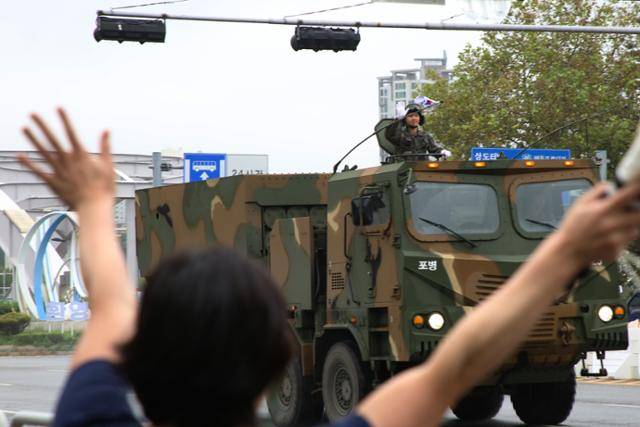 26일 오후 서울 용산구 한강대교에서 시민이 시가 행진을 하는 군 장병을 향해 손을 흔들고 있다. 정다빈 기자