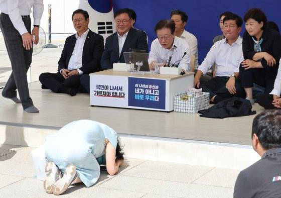 이재명 더불어민주당 대표가 지난 5일 오전 서울 여의도 국회 본청 앞 단식농성장에서 한 시민이 절을 하자 만류하고 있다. 뉴스1