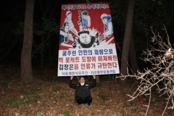 탈북민단체인 자유북한운동연합은 2021년 4월 25일부터 29일 사이 비무장지대(DMZ)와 인접한 경기도와 강원도 일대에서 대북전단을 살포했다고 주장했다. 사진은 박상학 자유북한운동연합 대표가 북한 정권을 규탄하는 플래카드를 들고 있는 모습이며 촬영 장소는 공개하지 않았다. 연합뉴스