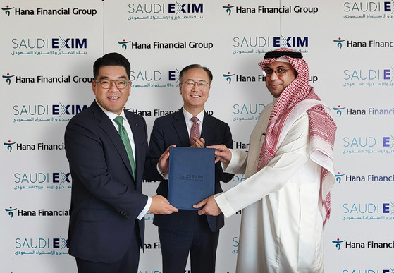 Hana Financial Group Vice Chairman Lee Eun-hyung, far left, poses for a photo with Park Joon-yong, South Korean ambassador to Saudi Arabia, middle, and Saudi Exim chief executive officer Saad Al-Khalb following the signing of a business agreement at the bank headquarters in Riyadh, Saudi Arabia on Monday. [HANA FINANCIAL GROUP]