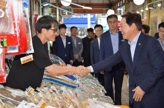박완수 경남도지사(오른쪽)가 거제시 고현시장을 찾아 상인 목소리를 청취하고 수산물을 구입하고 있다./사진제공=경남도