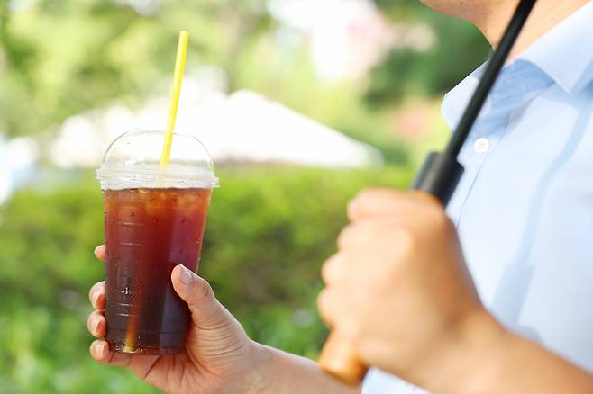 아이스 아메리카노를 마시며 늦더위를 식히고 있는 한 남성(사진은 기사 내용과 무관). [연합]