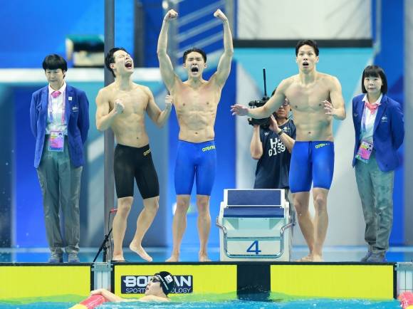 이호준(왼쪽부터), 김우민, 양재훈이 25일 중국 항저우 올림픽 스포츠센터 수영장에서 열린 2022 항저우 아시안게임 수영 남자 800m 계영 결선에서 금메달을 획득한 뒤 기뻐하고 있다. 항저우 연합뉴스
