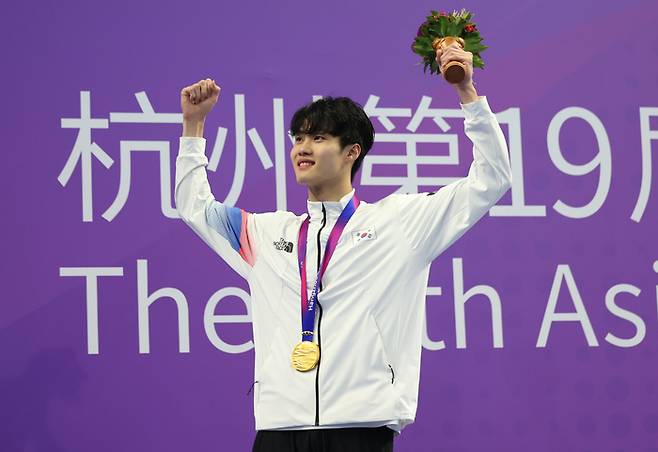 27일 중국 항저우 올림픽 스포츠센터 수영장에서 열린 2022 항저우 아시안게임 수영 남자 자유형 200ｍ 결승에 출전해 금메달을 획득한 황선우가 시상대에서 환호하고 있다. 사진 | 항저우=연합뉴스