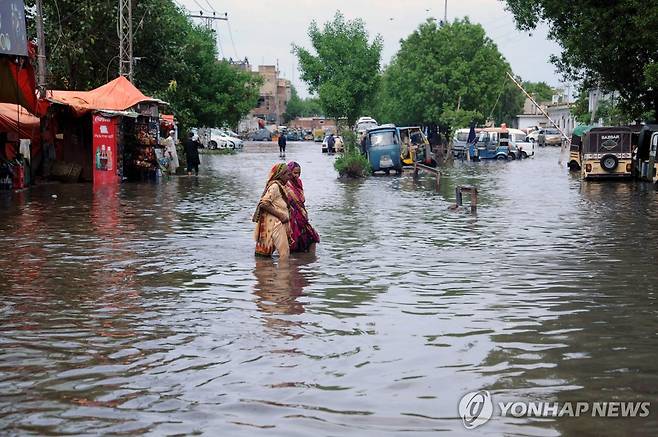 침수된 파키스탄 도로 (하이데라바드[파키스탄] EPA=연합뉴스) 2023년 7월 25일 파키스탄 남동부 신드주 하이데라바드시에서 시민들이 물이 찬 도로를 걷고 있다.