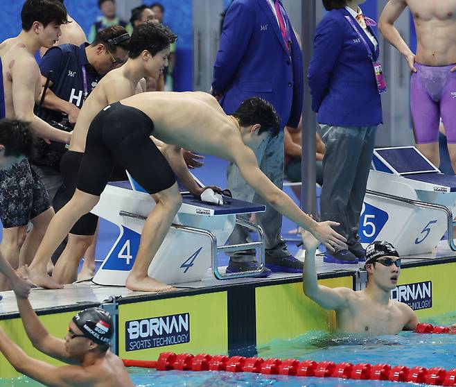 28일 중국 항저우 올림픽 스포츠센터 수영장에서 열린 항저우 아시안게임 남자 계영 400m 결승에 출전한 대표팀 선수들이 은메달을 확정한 뒤 마지막 주자인 황선우를 축하해주고 있다. 연합뉴스