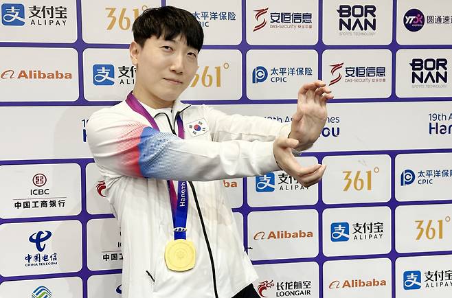 28일 중국 항저우 e스포츠센터에서 열린 2022 항저우 아시안게임(AG) 스트리트 파이터 V 결승전에서 대만의 샹여우린을 세트 점수 4-3으로 물리치고 금메달을 획득한 뒤 공동취재구역(믹스트존)에서 취재진을 향해 포즈를 취하고 있다. [연합]