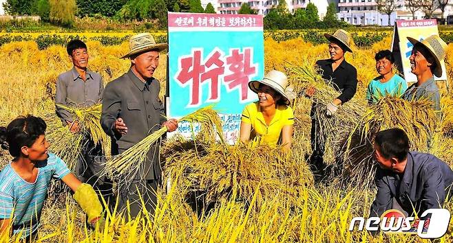 (평양 노동신문=뉴스1) = 북한 노동당 기관지 노동신문은 30일 "한 알의 낟알도 허실없이 나라의 쌀독에 넣기 위한 조직정치사업을 실속있게＂라면서 정주시 성남남새농장의 사진을 실었다. 한 일꾼(간부)이 '다수확'이란 문구 앞에서 농장원들에게 설명하고 있다. [국내에서만 사용가능. 재배포 금지. DB 금지. For Use Only in the Republic of Korea. Redistribution Prohibited] rodongphoto@news1.kr