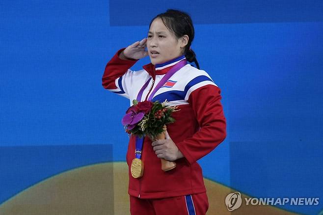 북한 리성금의 거수경례 (항저우 AP=연합뉴스) 북한 리성금이 30일 중국 저장성 항저우 샤오산 스포츠센터에서 열린 2022 항저우 아시안게임 역도 여자 49㎏급에서 우승한 뒤, 시상식에서 거수 경례를 하고 있다. 리성금은 북한군 산하 4·25 체육단 소속이다.