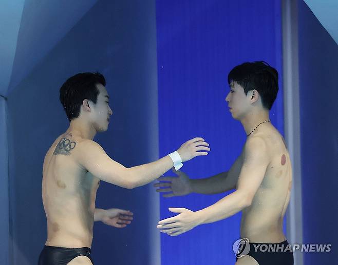 '함께 만든 은메달' (항저우=연합뉴스) 김인철 기자 = 30일 중국 항저우 올림픽 스포츠센터 수영장에서 열린 19회 항저우 아시안게임 다이빙 남자 싱크로 3m 스프링보드 결승에서 은메달을 차지한 우하람과 이재경이 연기를 마친 뒤 서로 격려하고 있다. 2023.9.30 yatoya@yna.co.kr